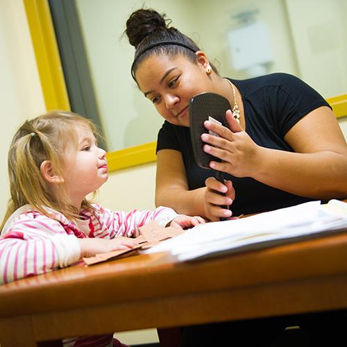 A student works with a young girl at the speech clinic.