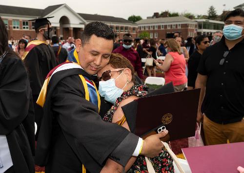 Iona grad Billy Falla embracing loved one at 2021 Commencement