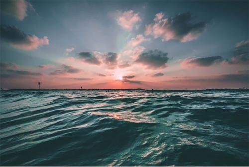 A pink and orange sunset over the ocean.