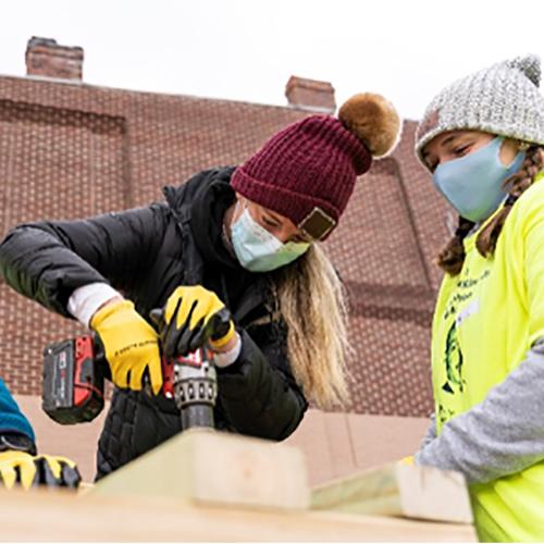 Students drill as they help build for Habitat for Humanity.
