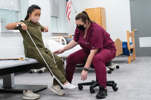 OT students practice doing a foot stretch.