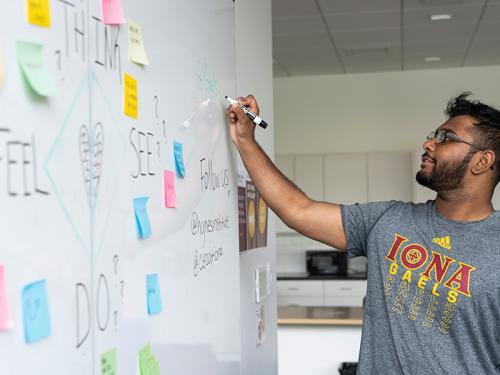 A student works on the whiteboard in the Hynes Institute.