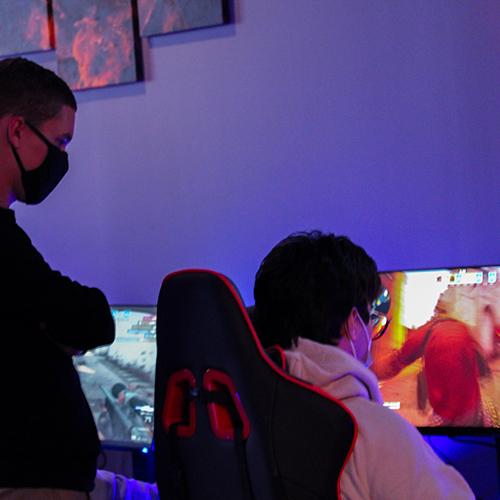 A coach works with an esports team member.