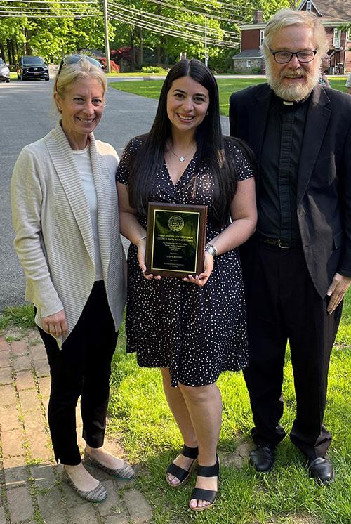 Mary Bongo holding her award with Iona University faculty.