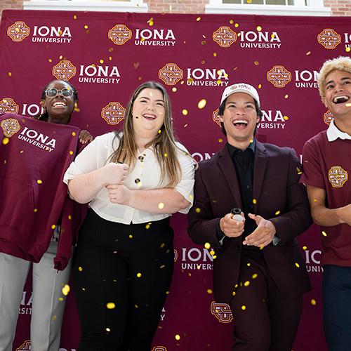 Four students celebrate the announcement of Iona University.