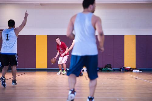A student dribbles the ball during a pick-up basketball game.