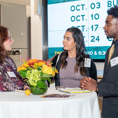 Three students talk at the mentoring program kick off.