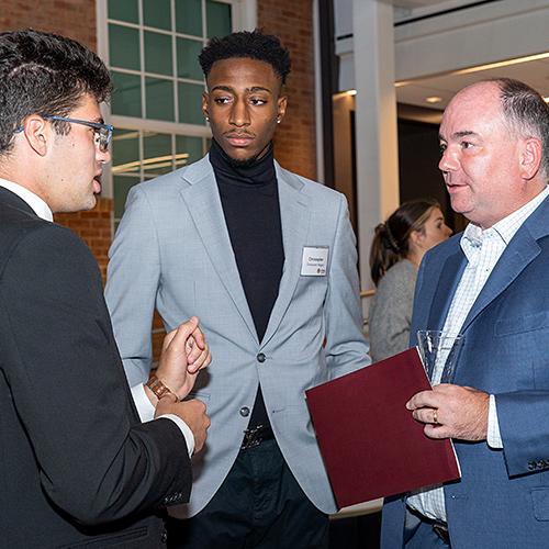 Jim Oates and student Chris Wiggin talk with another mentee.