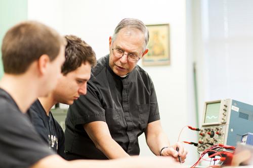 Br. Novak teaches two students in a Physics class.