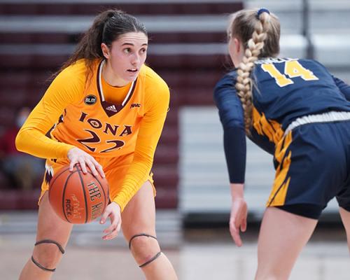 A member of the women's basketball team squares off with an opponent.