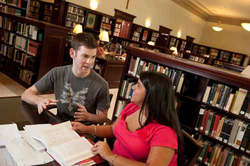 Two students discuss a text in the Ryan Library.