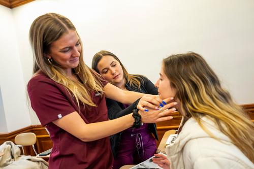 Three speech-language pathology students practice together.