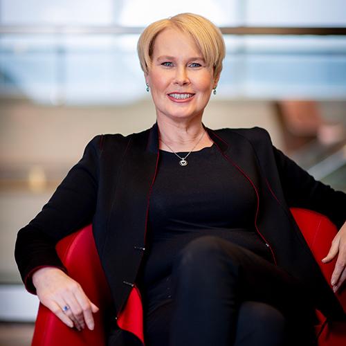 Maggie Timoney sitting in a red chair.