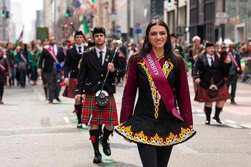 An Irish step dancer marches ahead of the pipe band in the St. Patrick's Day parade.