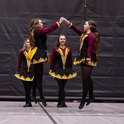 Two Irish dancers jump at the National Competition. 