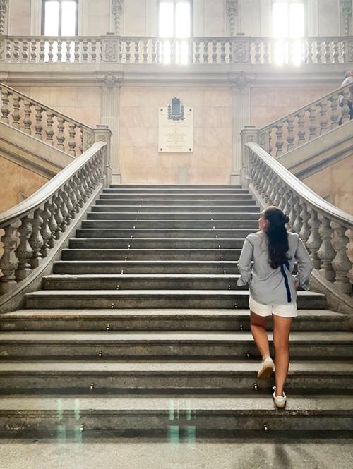 A student walks up the steps of a historic building in Portugal.