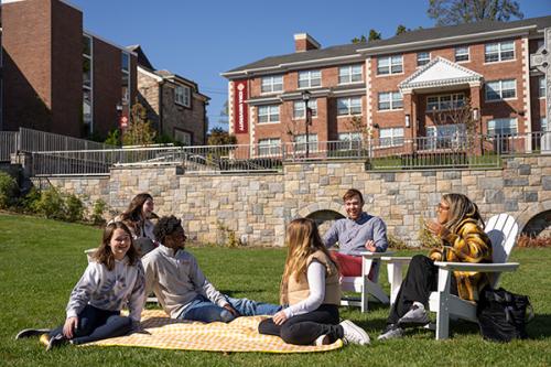 Students sit on the Murpy Green on a sunny day.