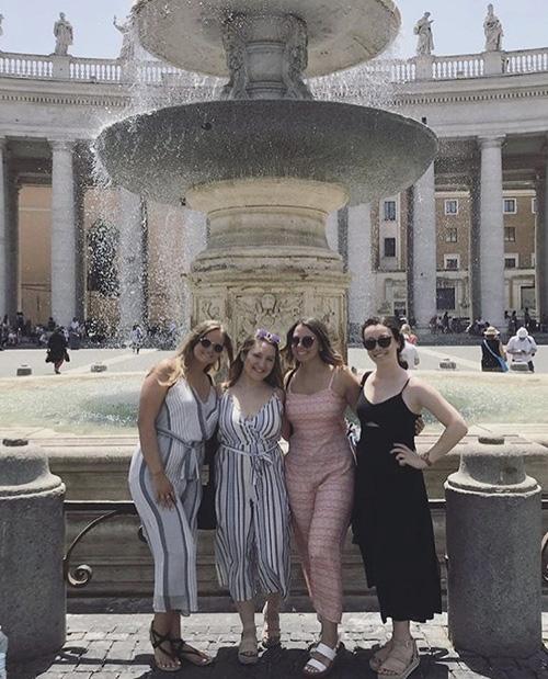 Four Iona students at a fountain in Barcelona.