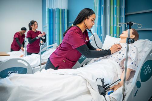 Students in the nursing education program work in the simulation lab.