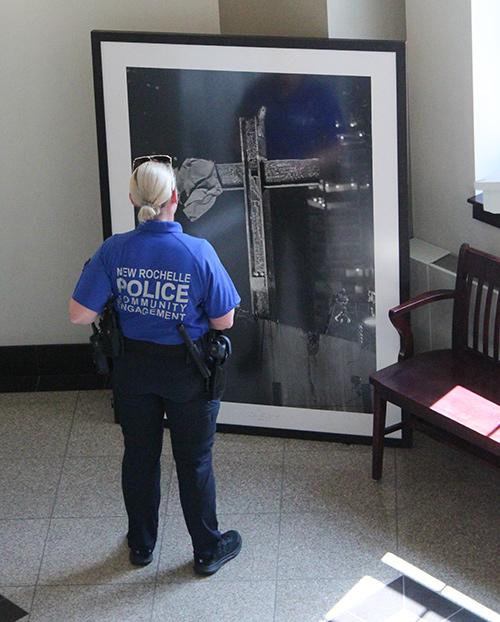 An officer looks at a picture at the John Botte 9/11 exhibit.