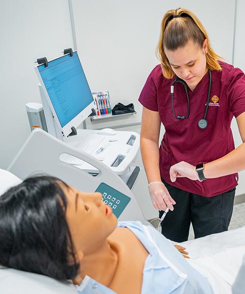 A nursing student looks at her watch as she measures blood pressure.