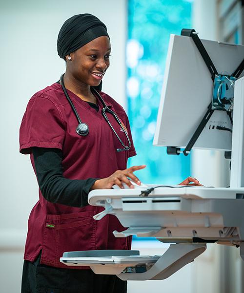 A nursing student works at a work station.