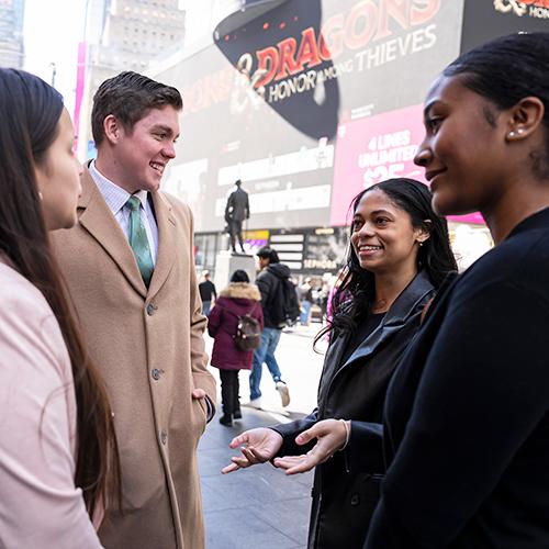 Four students in Times Square talking.