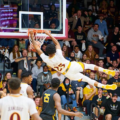 An Iona men's basketball player dunking at a game.