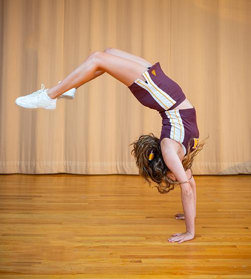 A student athlete does a handstand.