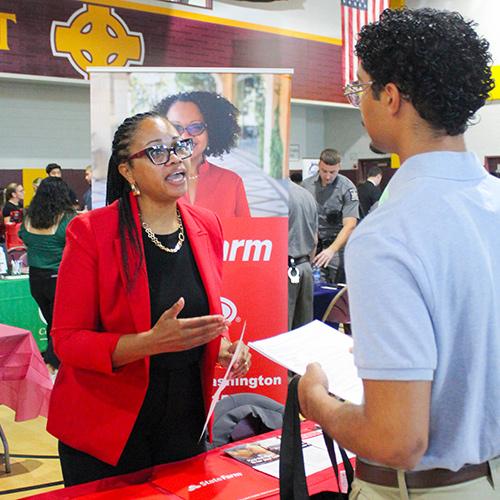 A student discusses opportunities at State Farm at the Career Fair.