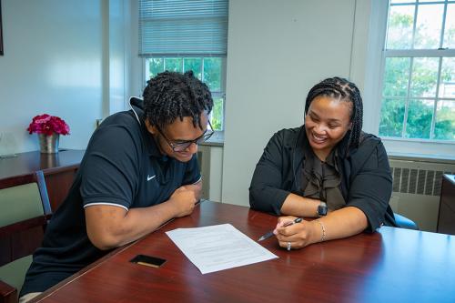 A career advisor helps a student with his resume.