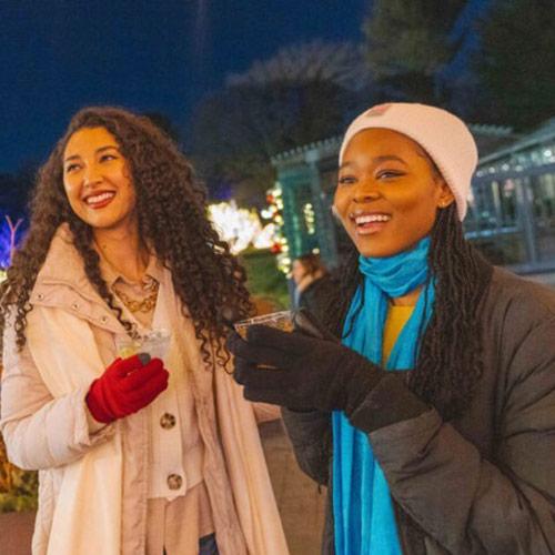 Two people enjoying holiday lights at NYBG.