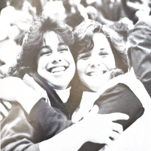 Two students from class of 1984 hugging for a photo.