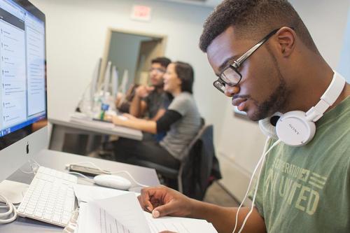 An information systems student works in a computer lab.