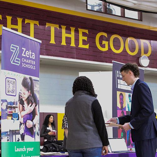 A student talks to a recruiter from Zeta Charter Schools at the Career Fair.