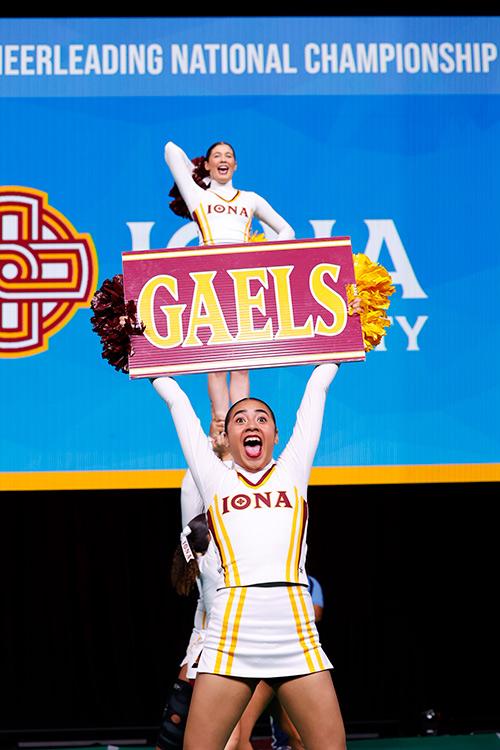 A member of the cheer team holds a Gaels sign as they compete nationals.