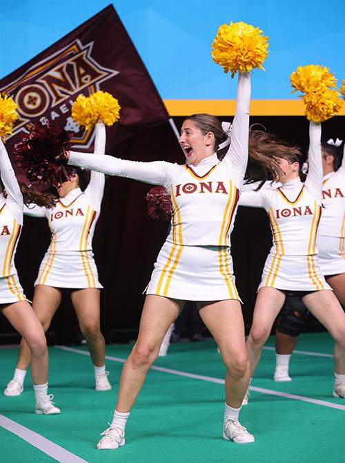 The cheer team performs with pom poms at nationals.