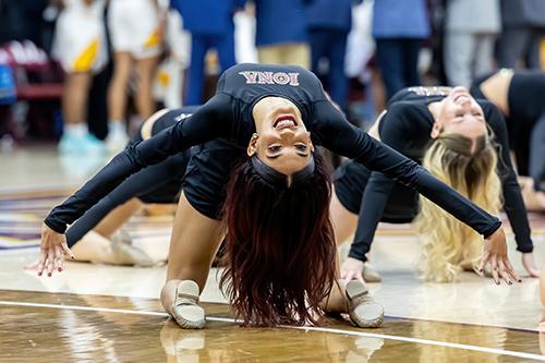 A dance team member does an upside down dance move.