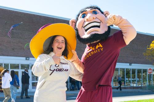 Killian lends his hat to an admitted student and she smiles.