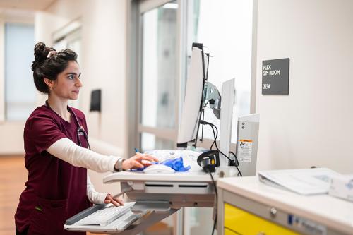 A nursing student works on a computer at a work station.