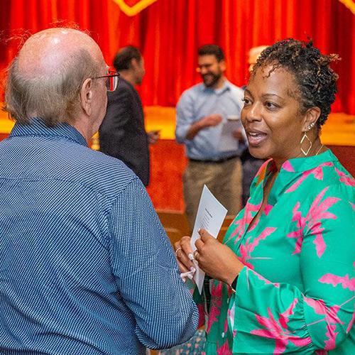 Dr. Nadine Cosby speaking to a colleague at a faculty event.