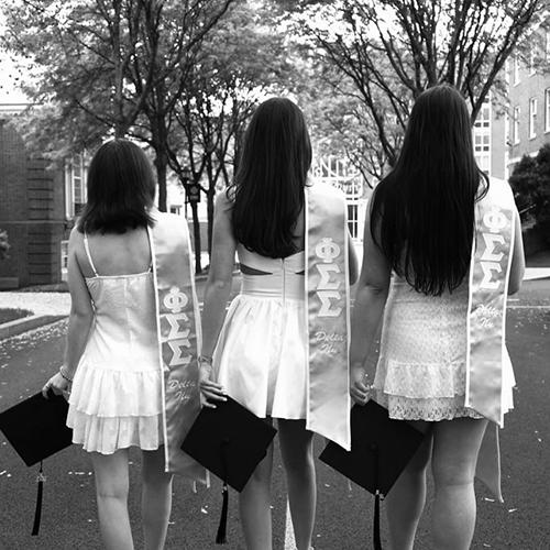 Three Phi Sig members dressed for Commencement.