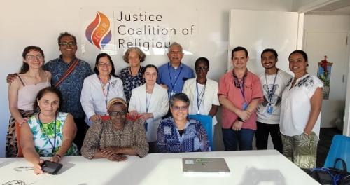 The Thomas Berry group in front of a Justice Coalition for Religious sign.
