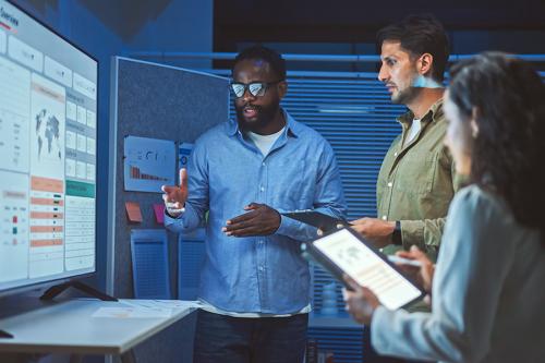 Employees review data using AI in an office.