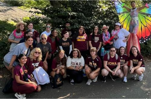 ASL club members taking a group photo at an event outside with a stilt performer.