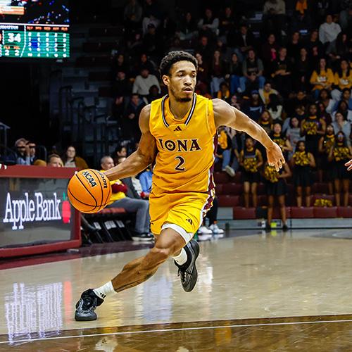 An Iona men's basketball player drives the ball down court.