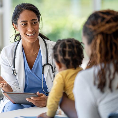 A family nurse practitioner works with a mother and her baby.