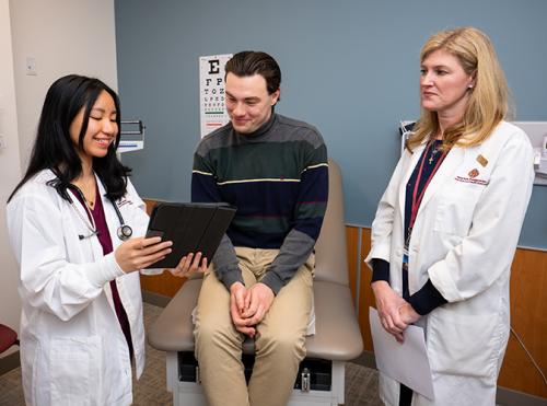 An FNP student and professor work with another student.