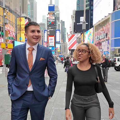 Two students walking through Times Square.