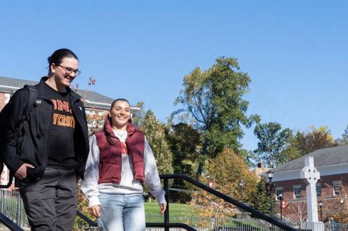 Two students walk near the Murphy Green on a sunny day.